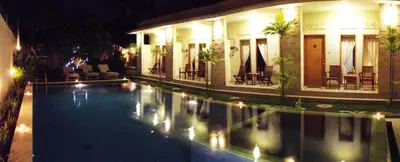 a swimming pool in front of a building at night at Alamanda Villa in Seminyak