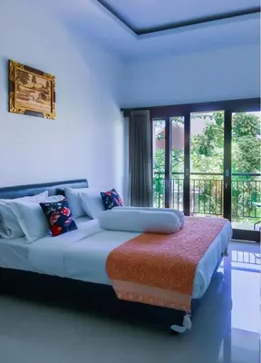 a bedroom with a large bed with a large window at Alamanda Villa in Seminyak