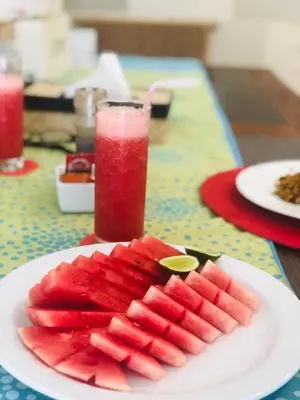 a plate of watermelon slices on a table with a drink at 3BR Villa Carissa Seminyak Centre, Bali by Le Ciel Hospitality in Seminyak