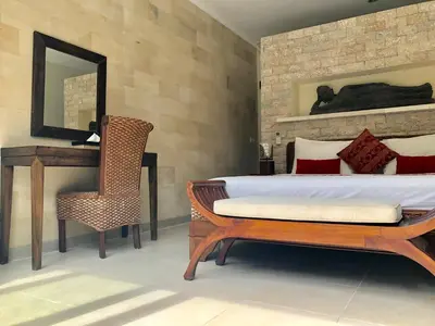 a bedroom with a bed and a chair and a mirror at 3BR Villa Carissa Seminyak Centre, Bali by Le Ciel Hospitality in Seminyak