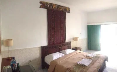 a bedroom with a bed with a wooden head board at Meriki Apartment in Seminyak