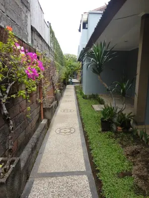a sidewalk next to a building with flowers on it at Meriki Apartment in Seminyak
