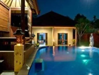 a large blue swimming pool in front of a house at Meriki Apartment in Seminyak