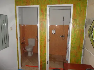 a bathroom with a toilet and a shower at Meriki Apartment in Seminyak