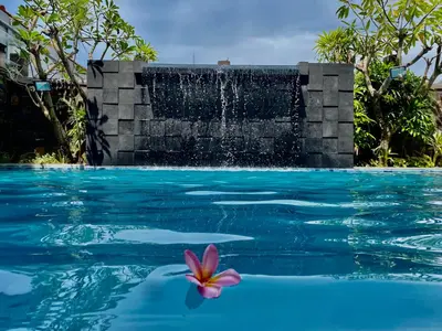 a flower in the water next to a fountain at Sun Royal Hotel in Kuta