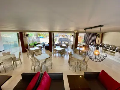 a living room with a couch and tables and chairs at Sun Royal Hotel in Kuta