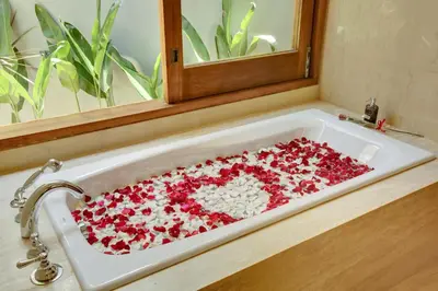 a bath tub filled with red and white flowers at KoenoKoeni Villa in Seminyak