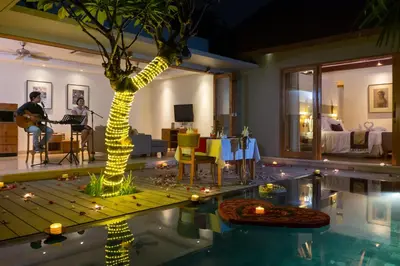 a living room with a palm tree and a pool at KoenoKoeni Villa in Seminyak
