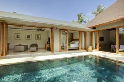 a villa with a swimming pool and a bedroom at KoenoKoeni Villa in Seminyak