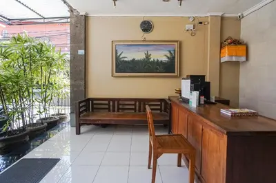 a waiting room with a bench in a restaurant at Gana Inn Legian in Legian