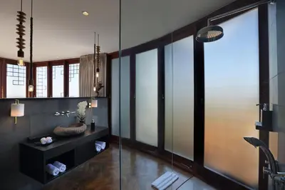 a bathroom with a glass shower and a sink at Dacolina House in Jimbaran