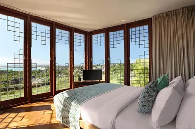 a bedroom with a bed with a view of the city at Dacolina House in Jimbaran