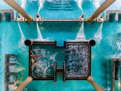 a picture of a pool with water coming out of it at AYANA Villas Bali in Jimbaran
