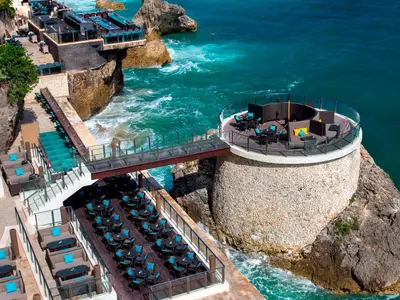 an aerial view of a restaurant on a cliff near the water at AYANA Villas Bali in Jimbaran