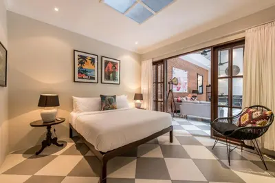 a bedroom with a bed and a table and a chair at Central 3 Bedroom Villa close to Seminyak Beach in Seminyak