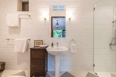 a white bathroom with a sink and a shower at Central 3 Bedroom Villa close to Seminyak Beach in Seminyak