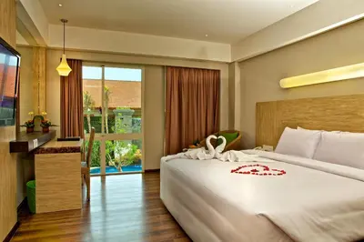 a bedroom with a large bed and a large window at Bintang Kuta Hotel in Kuta