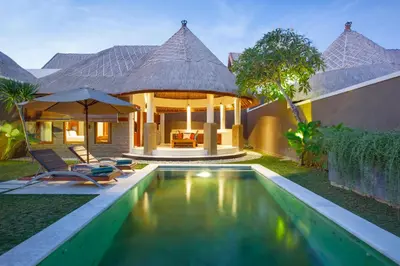a villa with a swimming pool and a house at Mutiara Bali Boutique Resort & Villa in Seminyak