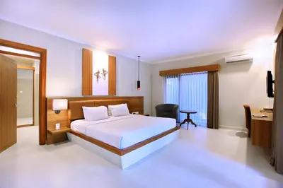 a bedroom with a bed and a desk and a chair at Mutiara Bali Boutique Resort & Villa in Seminyak
