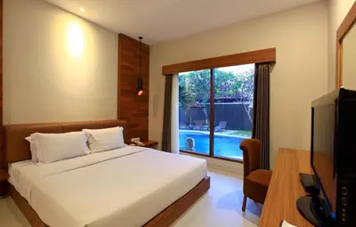 a bedroom with a bed and a tv and a window at Mutiara Bali Boutique Resort & Villa in Seminyak
