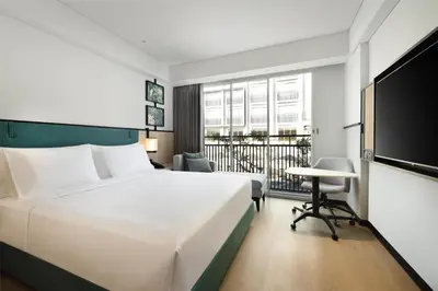 a hotel room with a large bed and a desk at Hilton Garden Inn Bali Nusa Dua in Nusa Dua