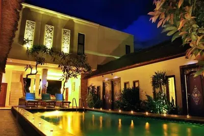 a swimming pool in front of a house at night at Sari Stay in Jimbaran