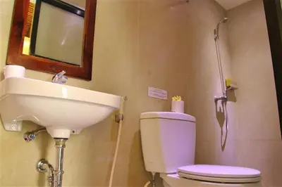 a bathroom with a sink and a toilet and a mirror at Sari Stay in Jimbaran