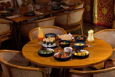a wooden table with bowls of food on it at Impiana Private Villas Seminyak in Seminyak