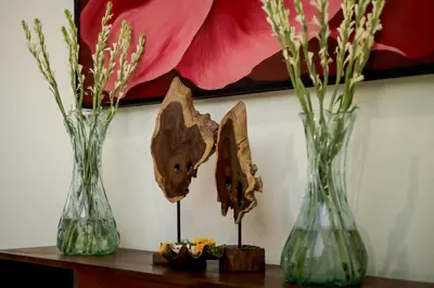 three vases sitting on a table with flowers in them at Fourteen Roses Boutique Hotel, Kuta in Legian
