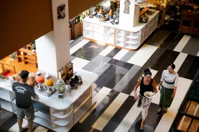 a group of people standing in a restaurant at Fourteen Roses Boutique Hotel, Kuta in Legian