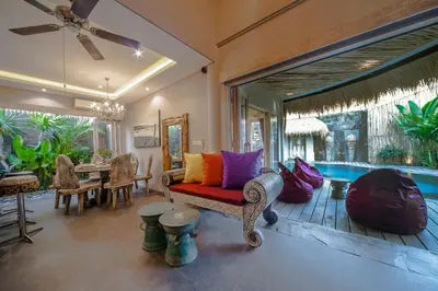 a living room with a couch and a pool at Luxury Villas Merci Resort 3BR Seminyak #1 in Seminyak