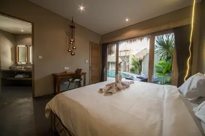 a bedroom with a large white bed with a window at Luxury Villas Merci Resort 3BR Seminyak #1 in Seminyak