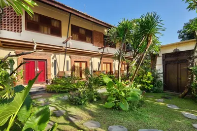 a house with a red door and some plants at Mahe Garden Kuta Villas by Kamara in Kuta