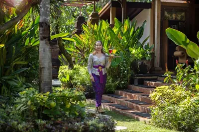 a woman walking down the stairs of a house at Mahe Garden Kuta Villas by Kamara in Kuta