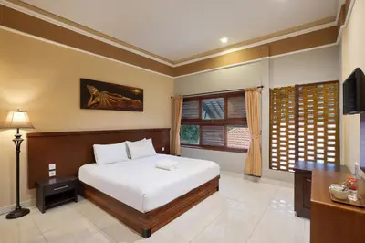 a bedroom with a bed and a television in it at Mahe Garden Kuta Villas by Kamara in Kuta