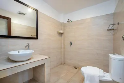 a bathroom with a sink and a toilet at Mahe Garden Kuta Villas by Kamara in Kuta