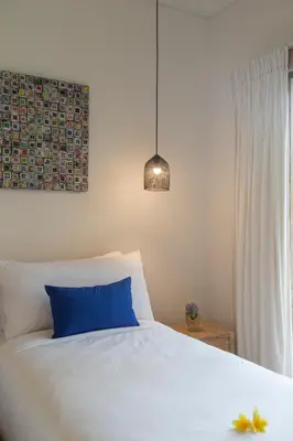 a bedroom with a blue pillow on a bed at Villa Arif in Seminyak