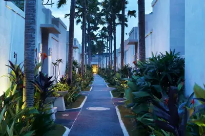 a walkway with palm trees and plants on a street at Daluman Villas in Seminyak