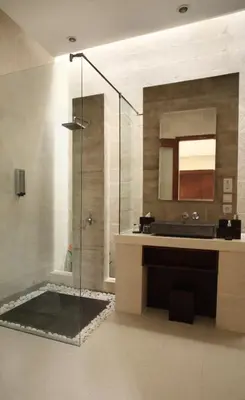 a bathroom with a shower with a sink and a mirror at Daluman Villas in Seminyak