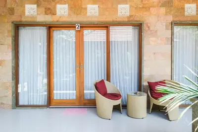 a group of chairs sitting in front of a window at Wayan House Seminyak in Seminyak