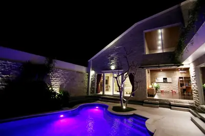 a house with a swimming pool at night at Villa Latour in Seminyak