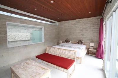 a bedroom with a bed and a red bench at Villa Latour in Seminyak