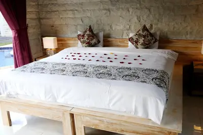 a bedroom with a large bed with white sheets and pillows at Villa Latour in Seminyak