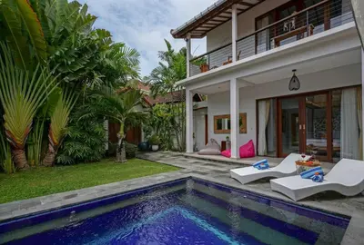 a villa with a swimming pool next to a house at Villa SU'KHA UMALAS in Canggu