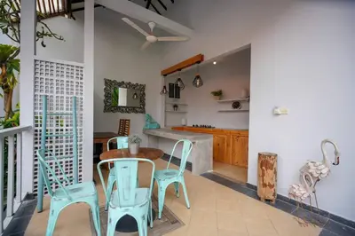 a kitchen with blue chairs and a wooden table at Villa SU'KHA UMALAS in Canggu