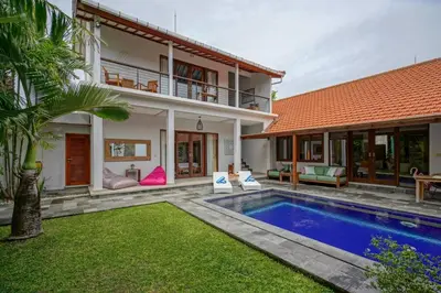 a villa with a swimming pool and a house at Villa SU'KHA UMALAS in Canggu