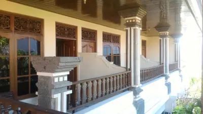 a porch of a house with columns and windows at Adus Beach Inn in Legian