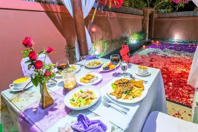 a table with plates of food and glasses of wine at Lavender Villa & Spa in Kuta