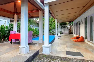 a patio with a red table and chairs at Lavender Villa & Spa in Kuta