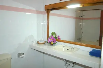 a bathroom with a sink and a mirror at Hotel Sorga Cottages in Kuta